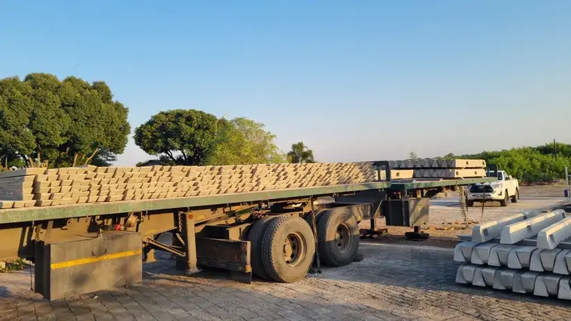 Concrete fencing components stacked on a flatbed trailer for transport